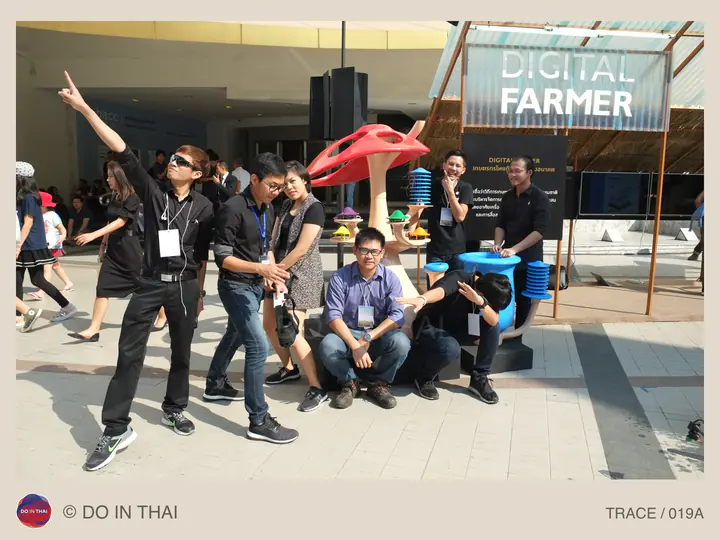 A group poses around colourful instruments beneath a Digital Farmer sign at an exhibition.