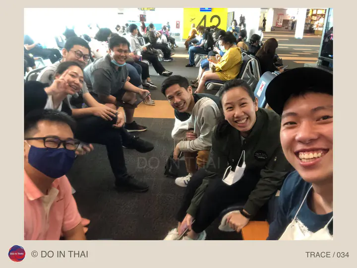 A team takes a selfie while waiting between rows of passenger seats.