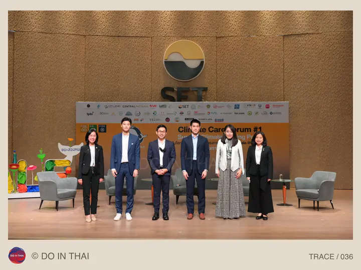 A group poses on a stage with a Climate Care Forum banner and SET emblem.