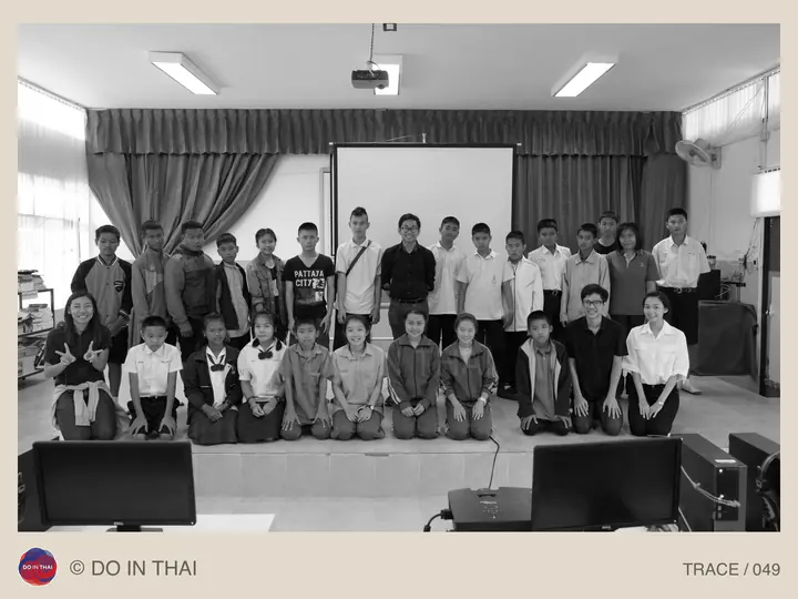 Black-and-white group photograph of adults and students together in a classroom.